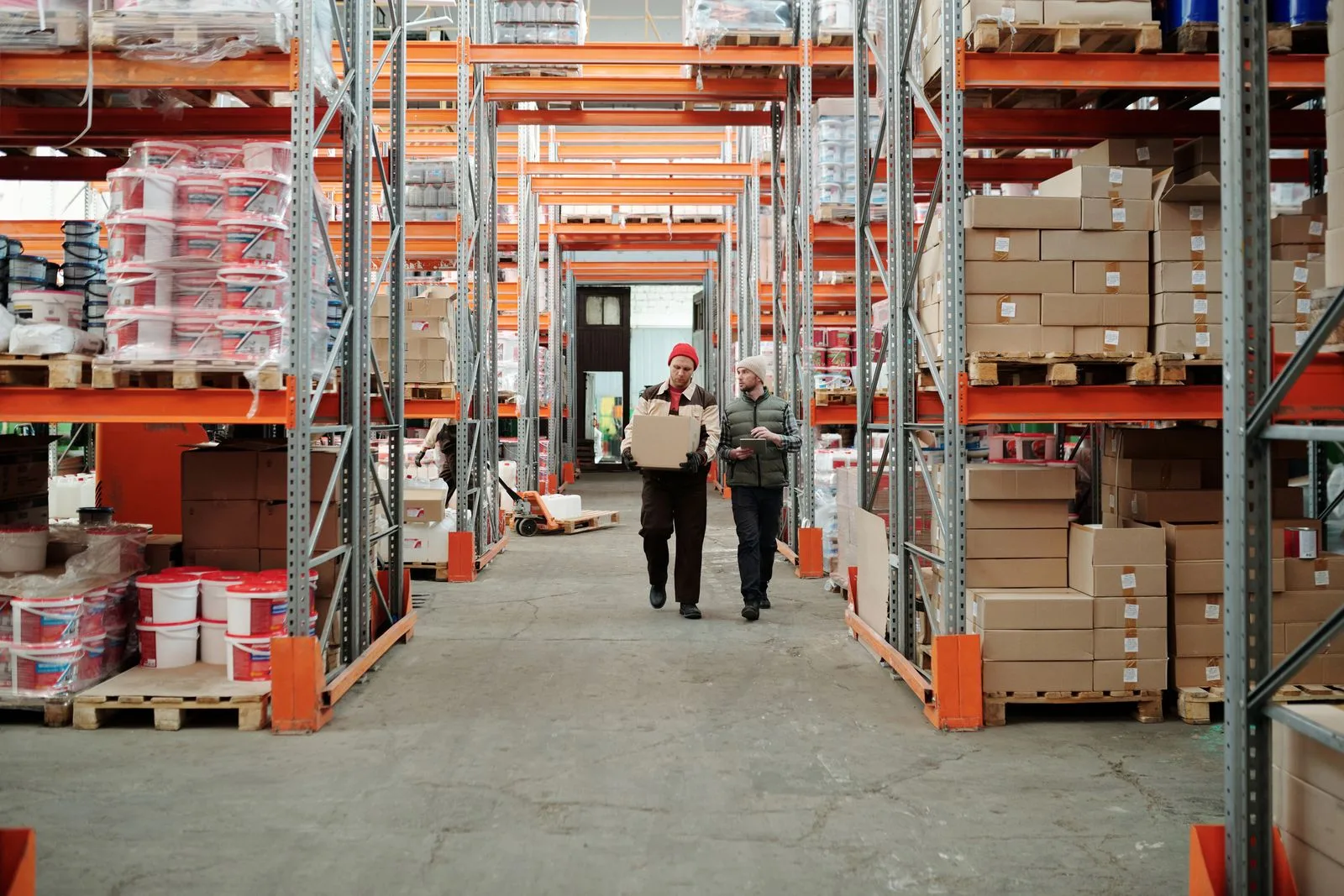 Colaborador caminhando entre corredores de um centro de distribuição